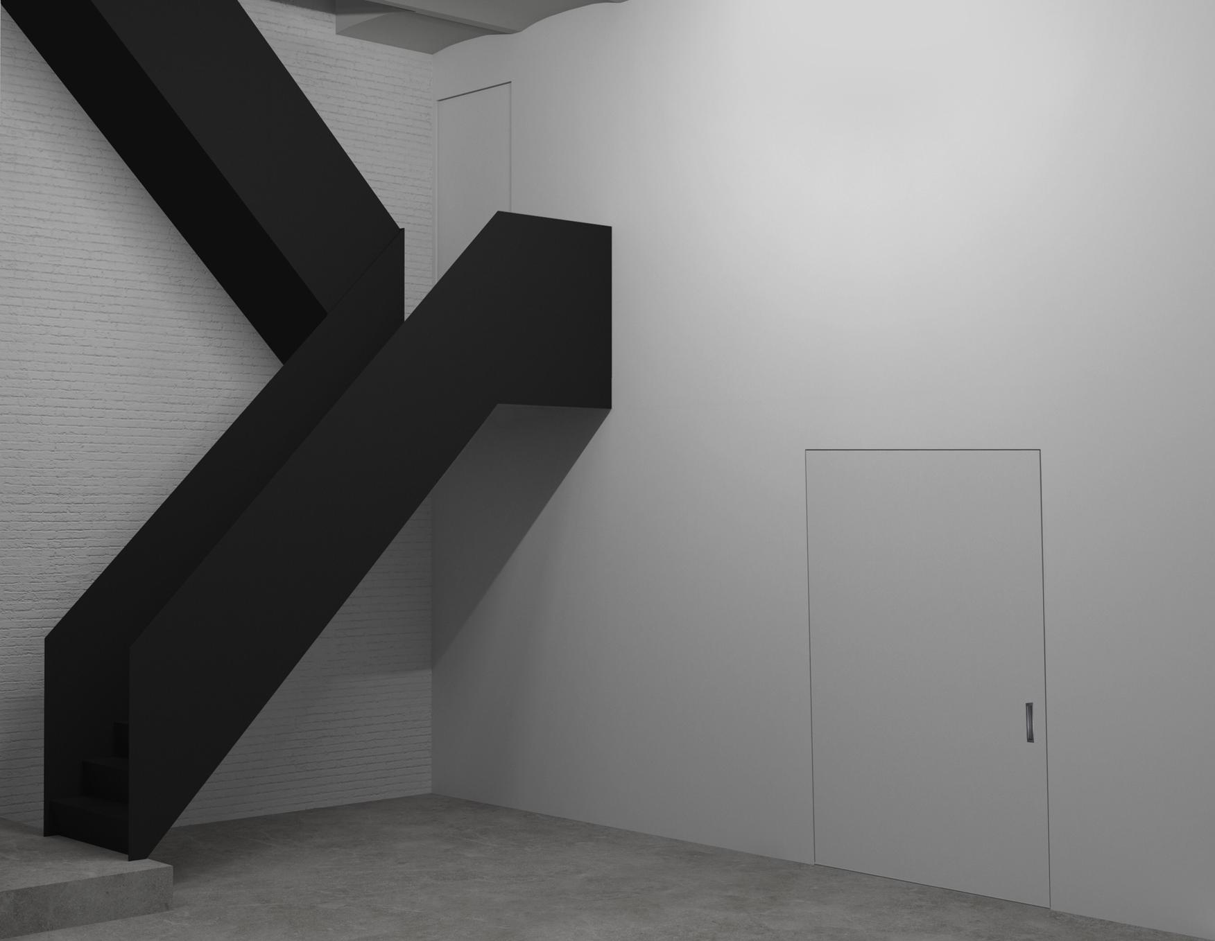 white gallery space with a black staircase on the left side of the photo
