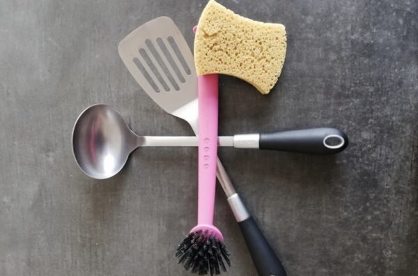 three kitchen utensils laying on top of each other on a grey countertop