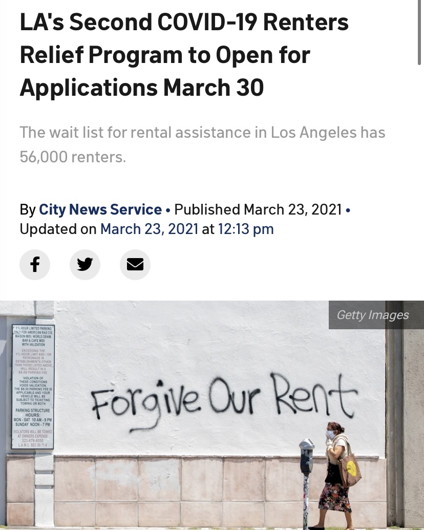 woman walking in front of a wall with forgive our rent spraypainted on it