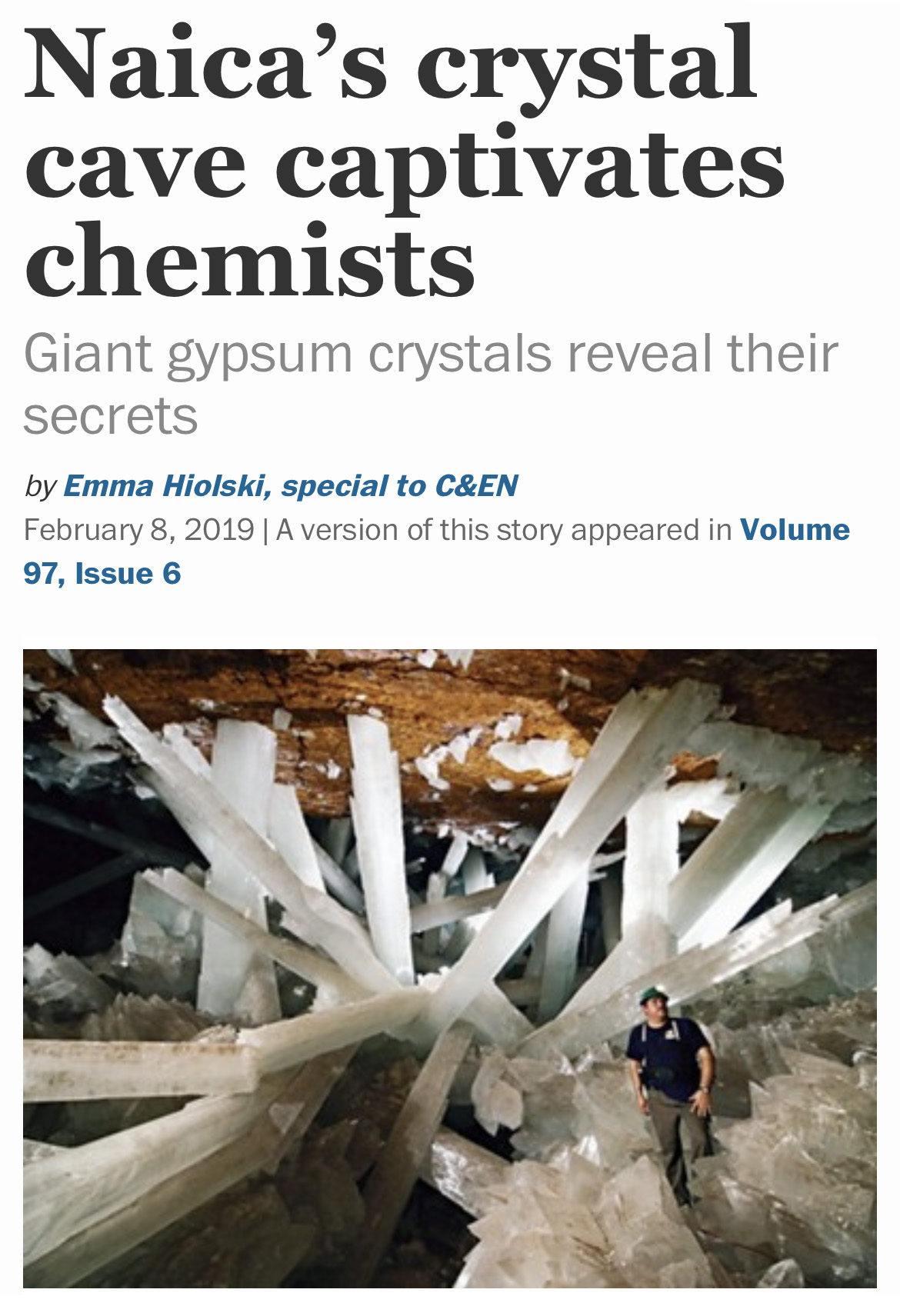 A man inside a cave with giant white crystals below a headline that reads "Naica’s crystal cave captivates chemists"