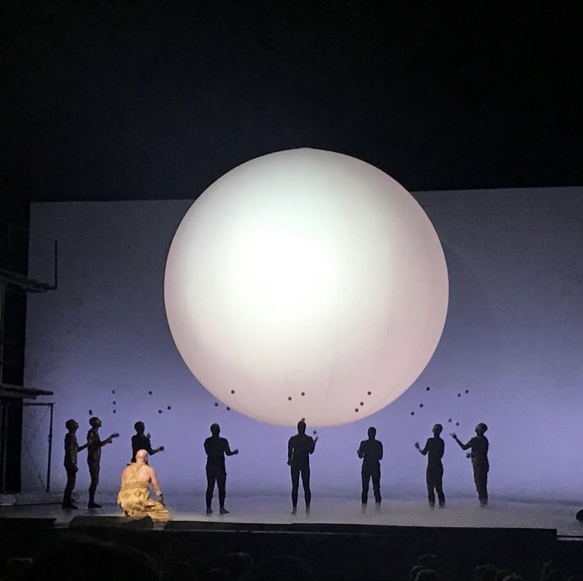 People standing below a glowing white orb