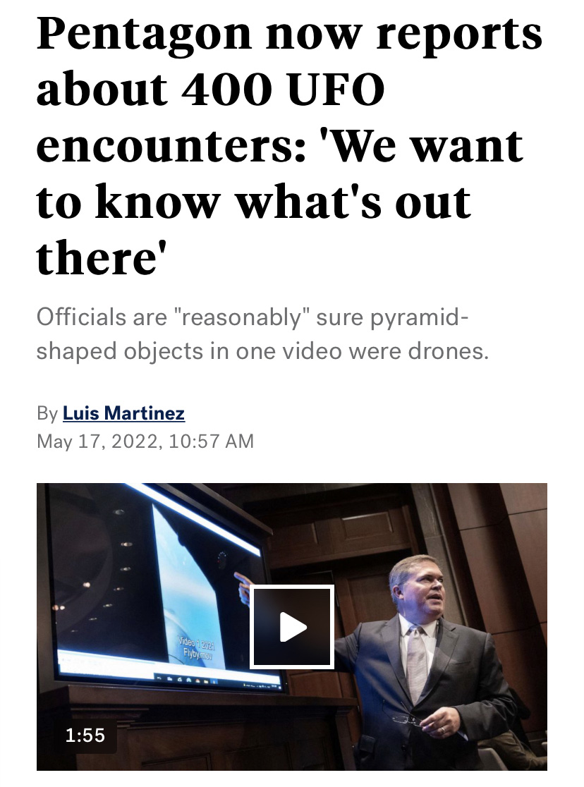 Scott Bray on a stage pointing at a screen beneath a headline that reads "Pentagon now reports about 400 UFO encounters: 'We want to know what's out there"