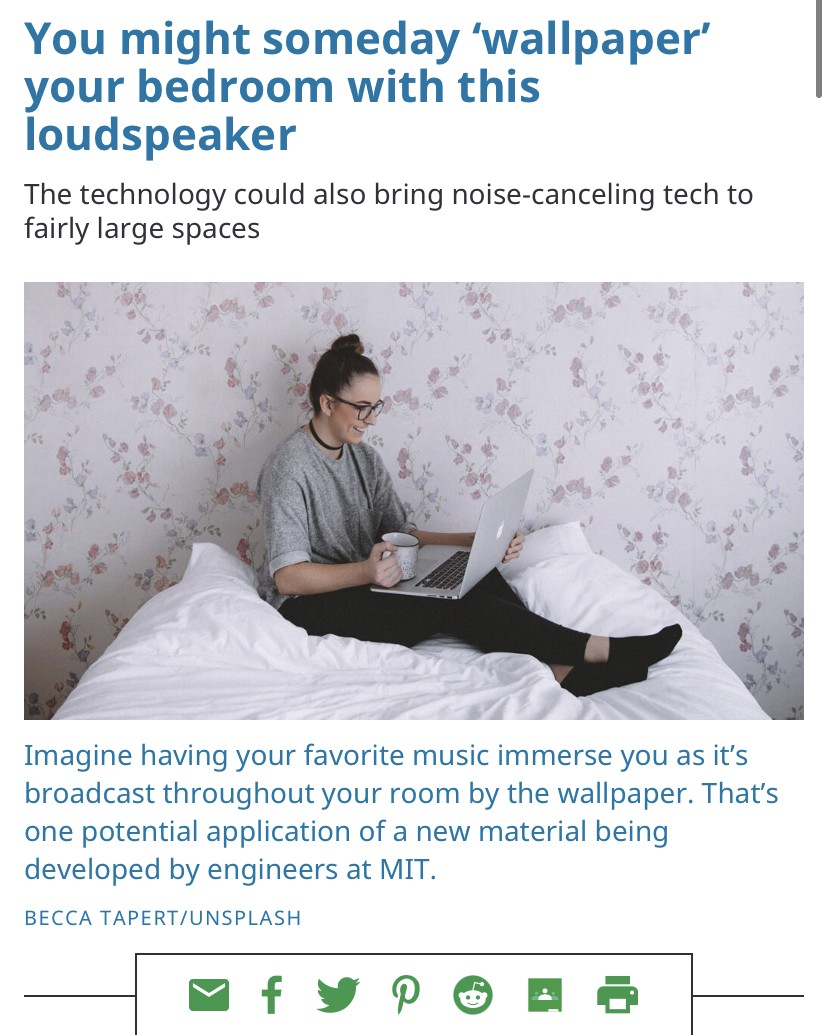 girl sitting smiling on her bed holding a mug and her laptop in a room covered with floral wallpaper beneath a headline that reads "You might someday ‘wallpaper’ your bedroom with this loudspeaker"