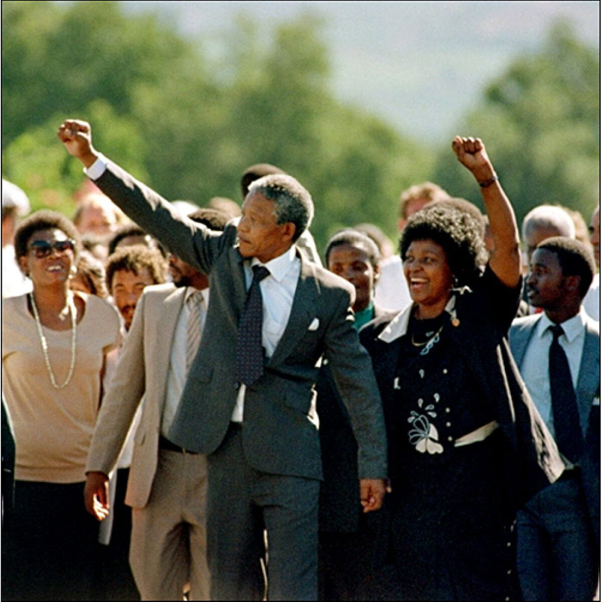 Nelson Mandela walking hand in hand with his wife Winnie Madikizela-Mandela, raising their fists after his release from prison
