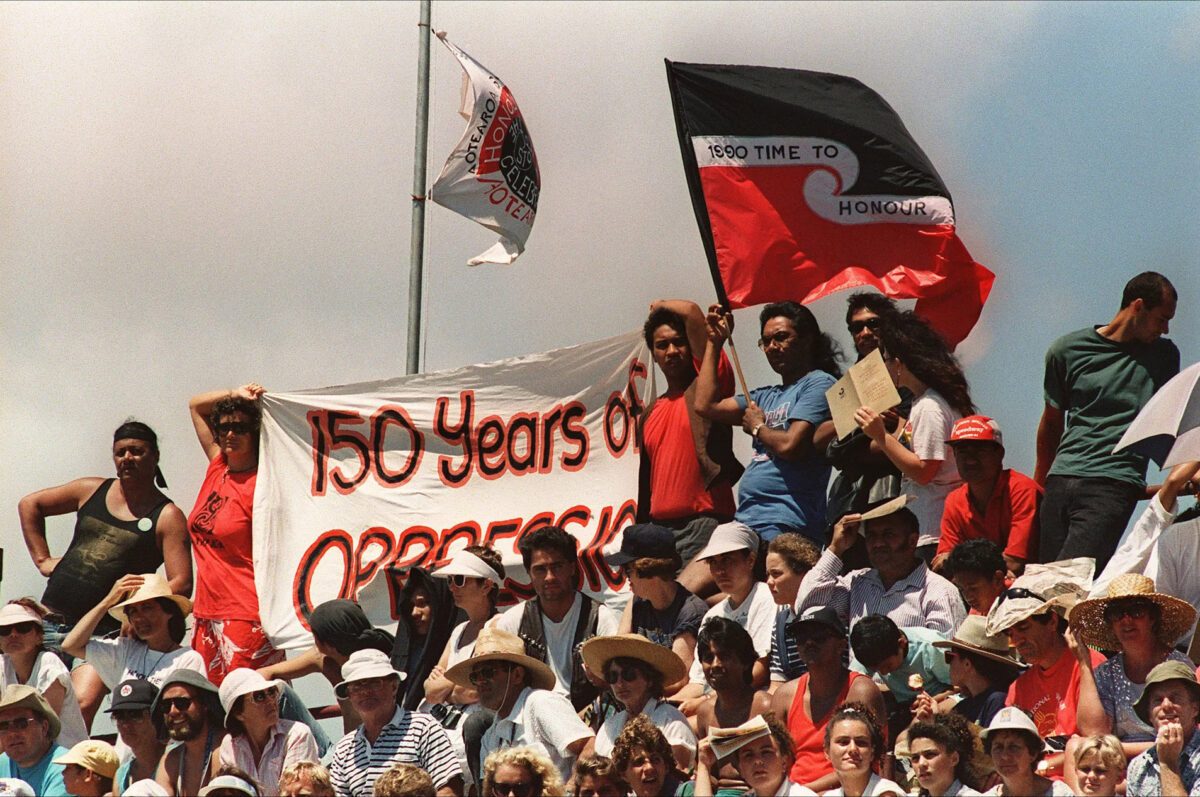 Māori protesters hold banners and streamers asking Queen Elizabeth II to honor the treaty of Waitanagi during the Waitanagi Day celebrations in Waitanagi, New Zealand, on February 6, 1990