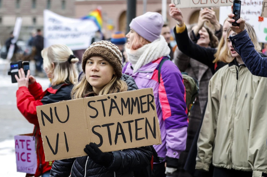 Greta Thurnberg holding a protest sign that reads "Nu Stammer Vi Staten" (Now we sue the State)